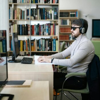 Rechtenvrije foto van een blind persoon die achter een laptop zit.